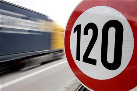 A truck passes a 120 km/h (75 mph) speed limit sign